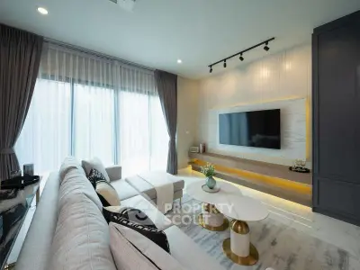 Modern living room with stylish decor and large TV, featuring elegant curtains and cozy seating.