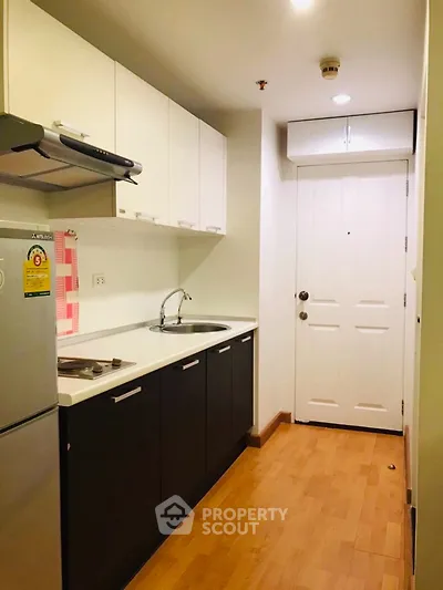 Modern compact kitchen with sleek cabinets and wooden flooring