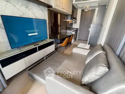 Modern living room with sleek furniture and open kitchen layout in a stylish apartment.
