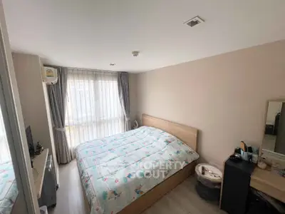 Cozy bedroom with large window and modern furnishings in a bright apartment.