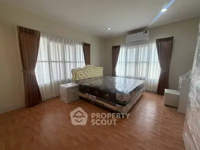 Spacious bedroom with elegant bed and natural light from large windows