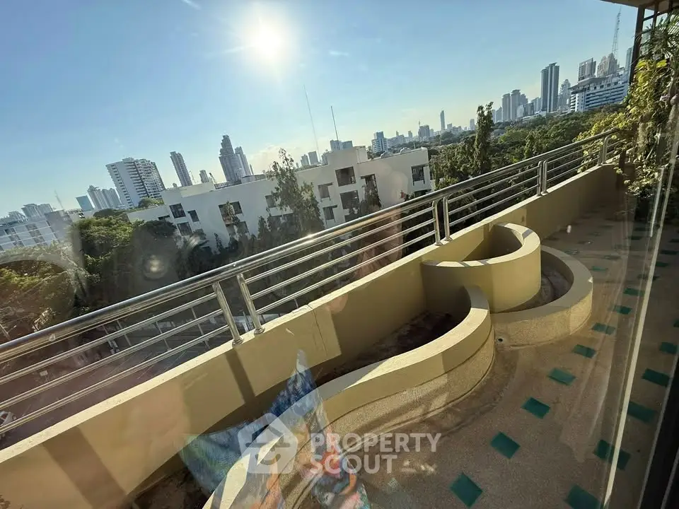 Stunning cityscape view from a spacious balcony with modern railings and lush greenery.