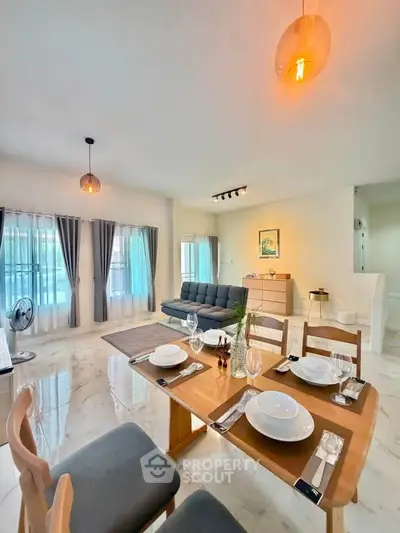 Spacious modern living room with dining area, elegant decor, and natural light