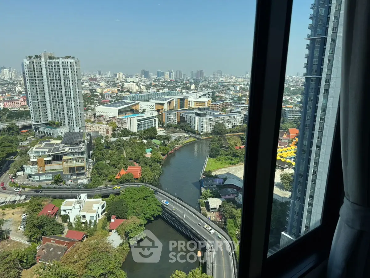 Stunning high-rise cityscape view from a modern apartment window showcasing urban skyline and river.