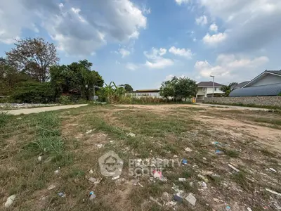 Vacant land plot with potential for development under a clear blue sky.