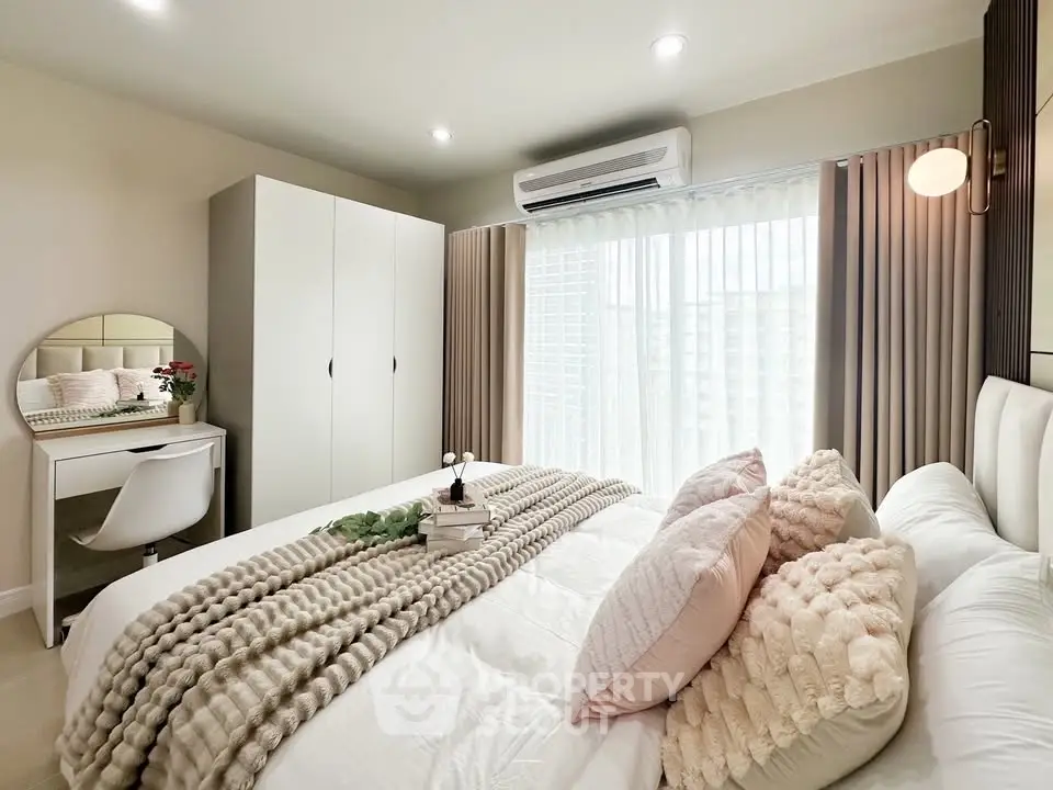 Cozy bedroom with modern decor, featuring a plush bed, stylish vanity, and ample natural light.