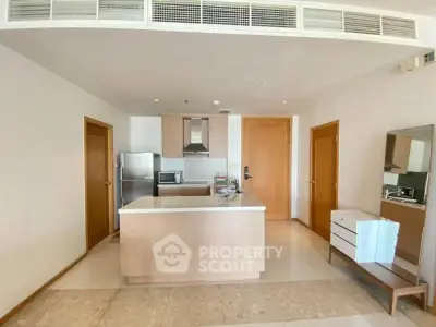 Modern kitchen with island and stainless steel appliances in open layout apartment.