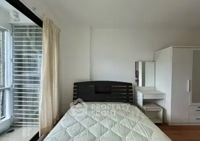 Cozy bedroom with large window and modern furniture in a bright apartment.