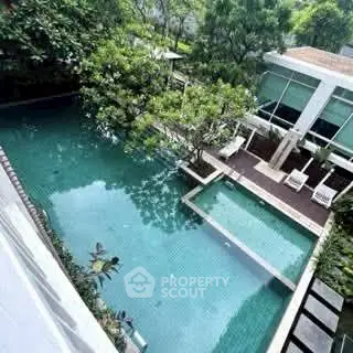 Luxurious outdoor pool area with lush greenery and modern architecture, perfect for relaxation and leisure.