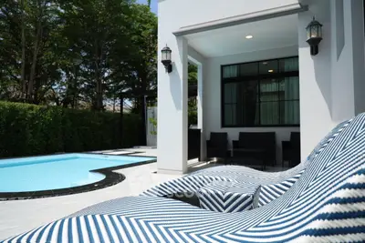 Luxurious modern home with private pool and stylish outdoor seating area.