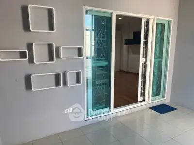 Modern apartment with stylish sliding glass doors and decorative wall accents.