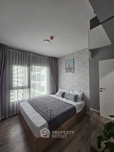 Modern bedroom with stylish decor and large window for natural light.