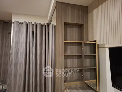 Modern interior with built-in wooden shelves and elegant curtains in a cozy living space.