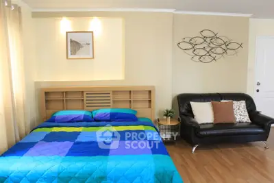 Cozy bedroom with modern decor and stylish wall art, featuring a comfortable bed and elegant sofa.