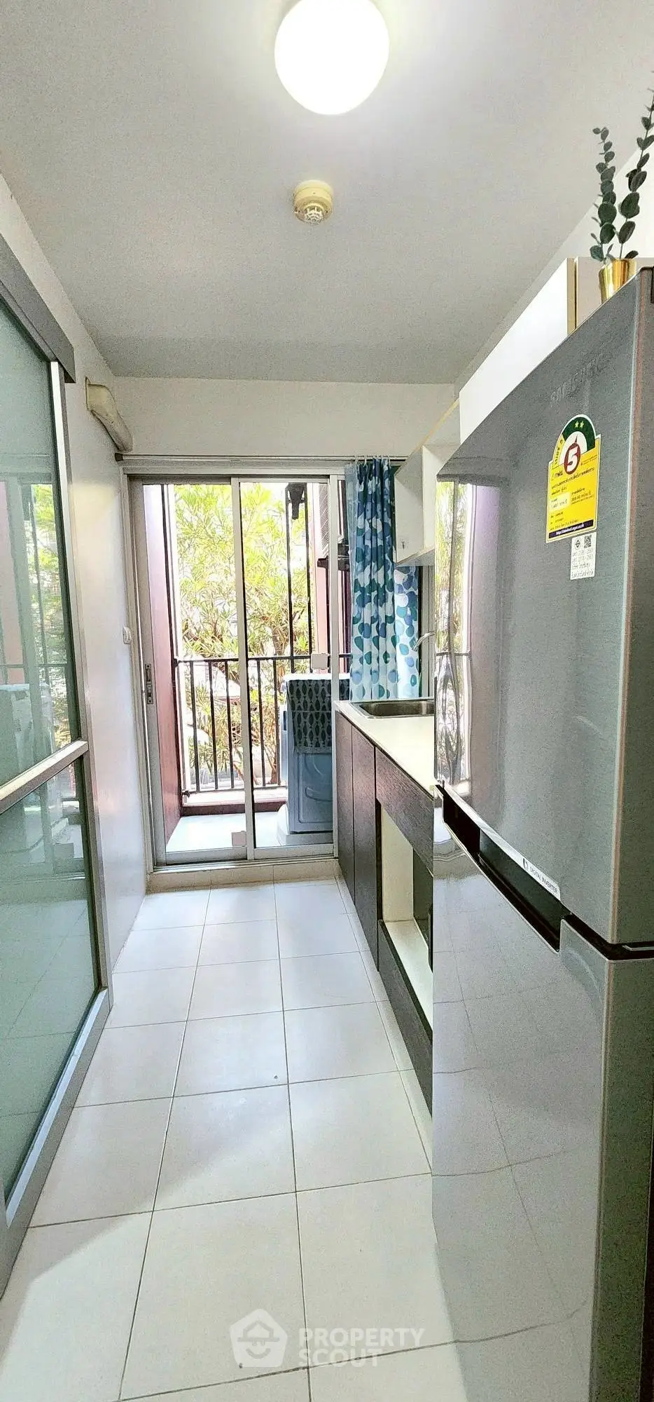 Modern kitchen with sleek appliances and balcony view in urban apartment