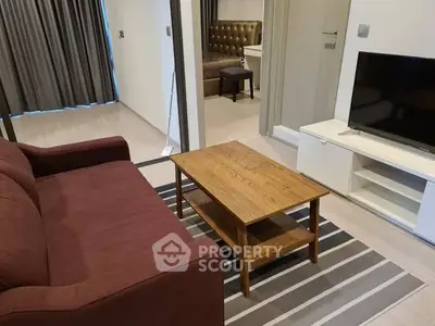 Modern living room with cozy sofa and flat-screen TV, perfect for relaxation.