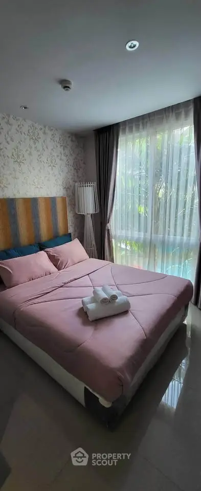 Cozy bedroom with elegant decor and large window offering natural light