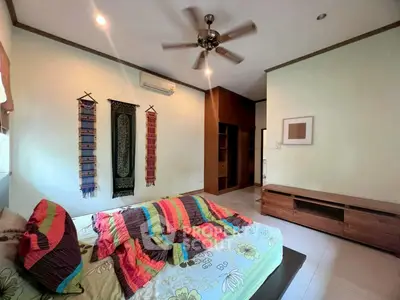 Spacious bedroom with modern decor and ceiling fan