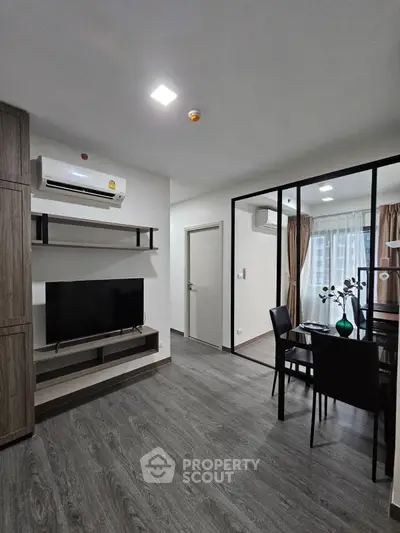Modern living room with sleek design and dining area, featuring large windows and stylish decor.