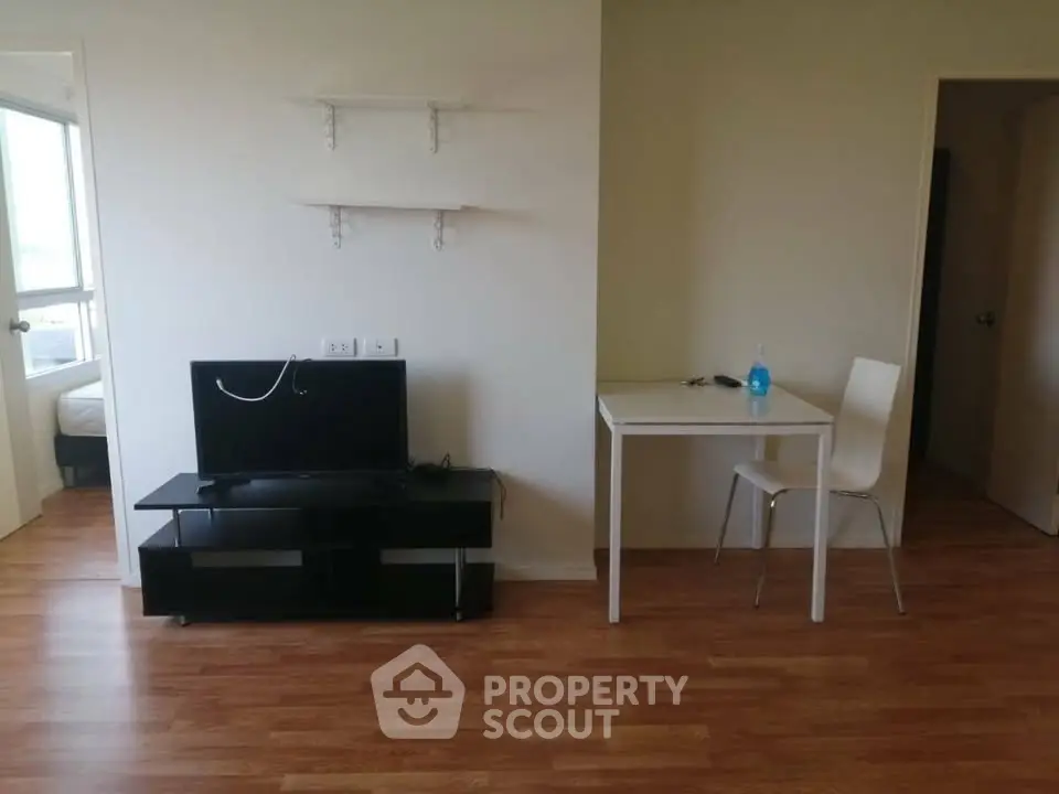 Minimalist living room with TV stand and small dining table on wooden floor