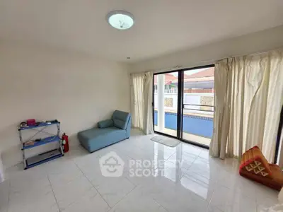 Spacious living room with large windows and pool view, featuring minimalist furniture.