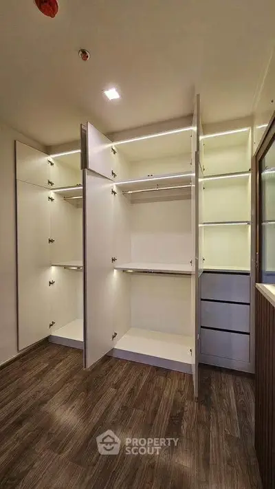 Spacious walk-in closet with modern shelving and wooden flooring