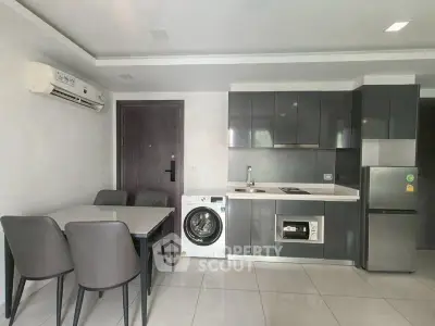 Modern kitchen with sleek cabinets, dining area, and built-in appliances in a stylish apartment.