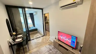 Modern apartment interior with cozy living room and stylish bedroom separated by glass partition.