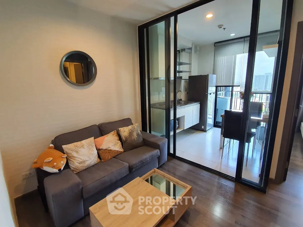 Modern living room with glass partition and cozy kitchen area