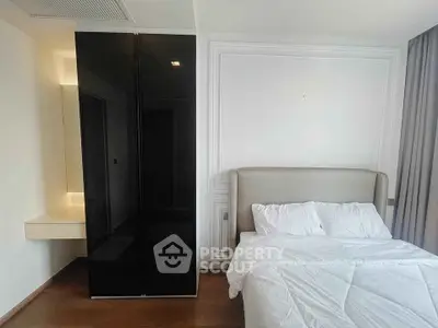 Modern bedroom with sleek black wardrobe and cozy bed in stylish apartment.