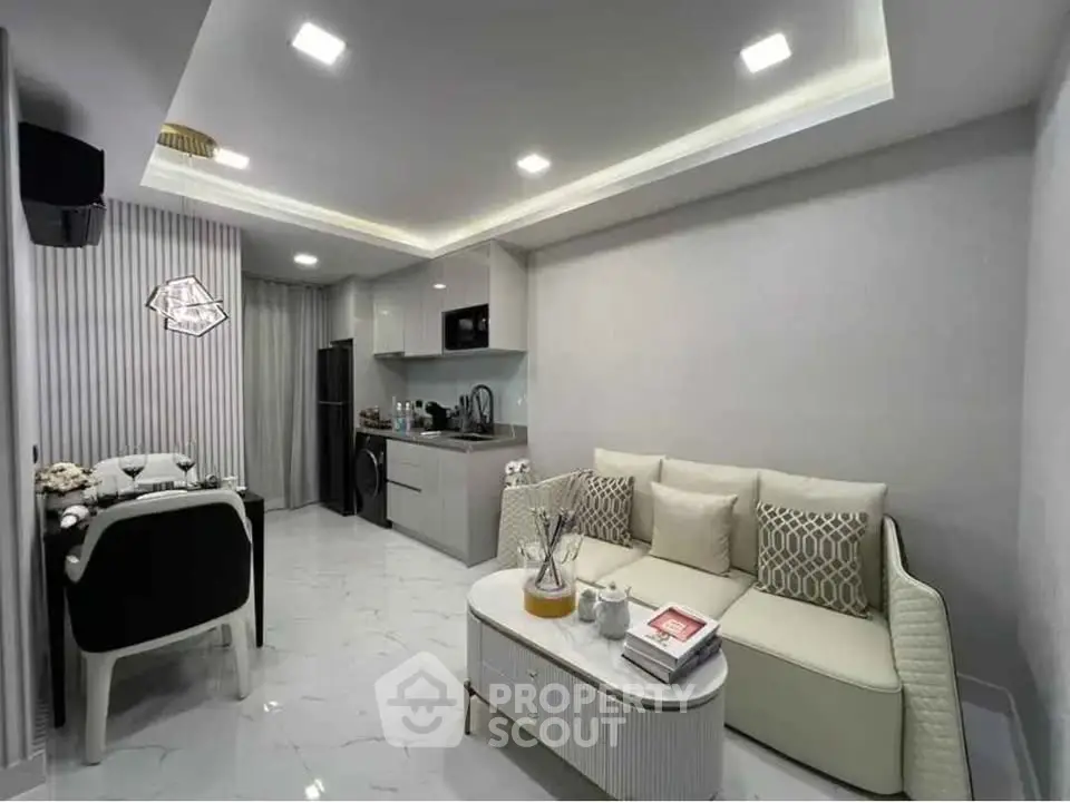 Modern living room with open kitchen, sleek furniture, and elegant lighting