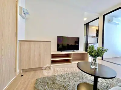 Modern living room with sleek furniture and open layout, featuring a flat-screen TV and stylish decor.