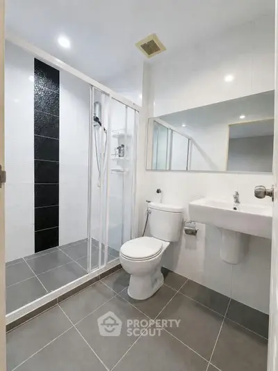 Modern bathroom with sleek shower and elegant fixtures in a contemporary apartment.