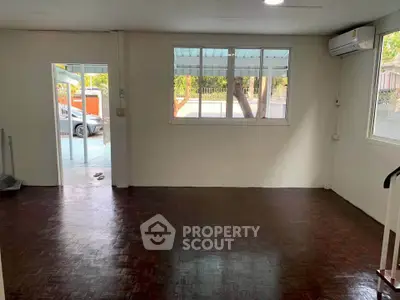 Spacious living room with large windows and air conditioning, offering a bright and airy atmosphere.