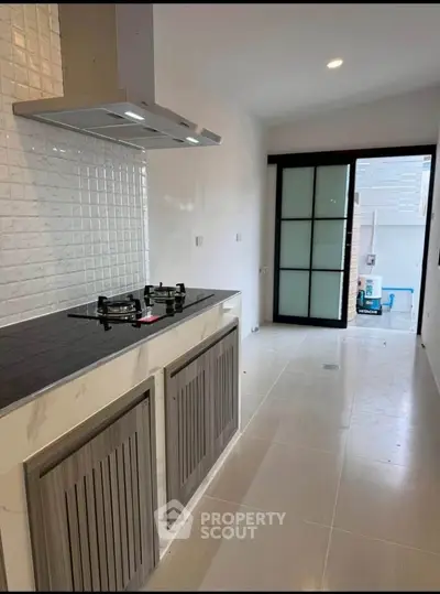 Modern kitchen with sleek gas stove and stylish cabinetry in a bright, minimalist design.
