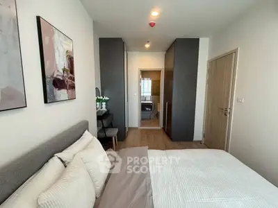 Modern bedroom with stylish decor and ensuite bathroom in a contemporary apartment.