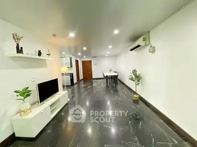 Spacious modern living room with sleek black marble flooring and minimalist decor