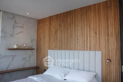 Modern bedroom with wood panel accent wall and marble details, featuring a cozy bed and elegant lighting.