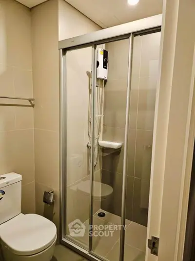 Modern bathroom with glass shower enclosure and sleek fixtures.