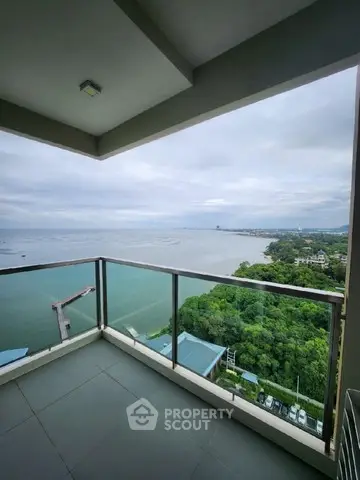 Stunning ocean view from high-rise balcony with glass railing