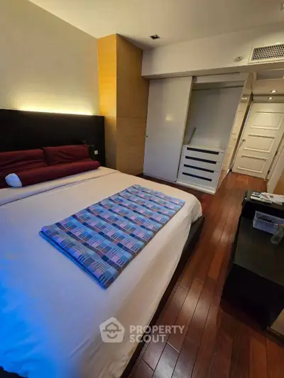 Spacious bedroom with wooden flooring and modern decor
