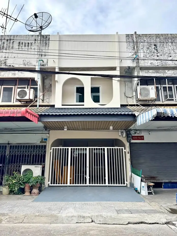 Charming townhouse exterior with modern facade and gated entrance in urban setting.