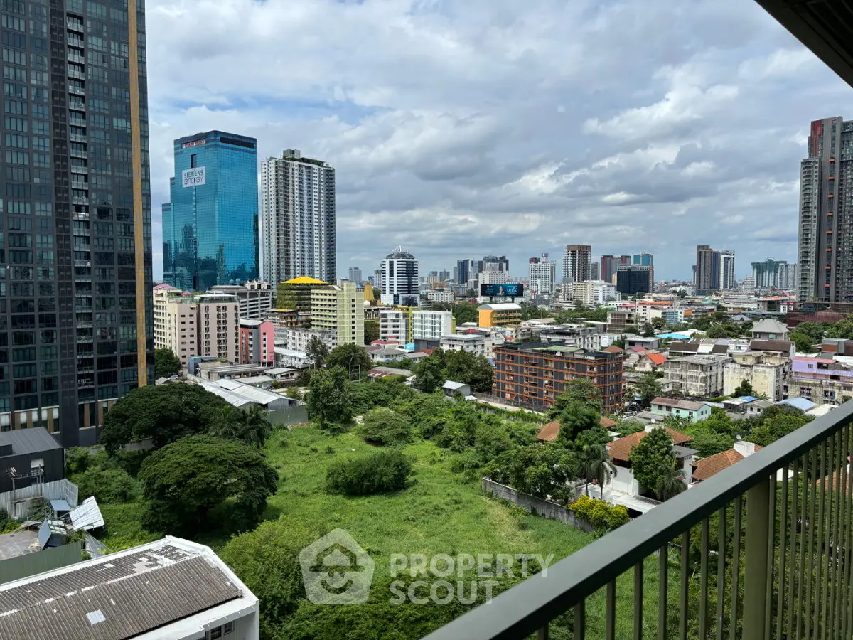 Stunning cityscape view from a high-rise balcony overlooking lush greenery and modern skyscrapers.