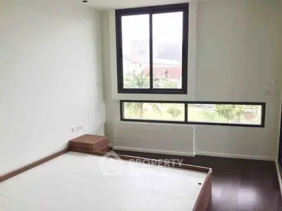 Spacious bedroom with large windows offering natural light and scenic views.