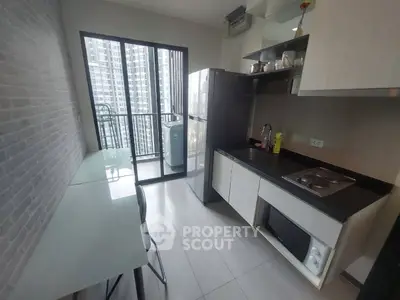 Modern kitchen with sleek appliances and balcony view in urban apartment