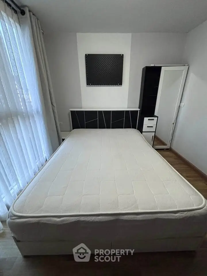 Modern bedroom with large window and stylish furniture, perfect for cozy living.