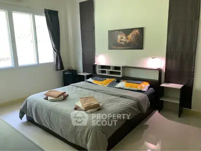 Spacious bedroom with modern decor and large windows for natural light.