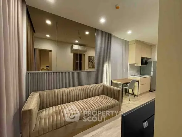 Modern living room with stylish sofa and open kitchen layout in a cozy apartment.