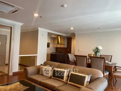 Spacious living room with elegant dining area and modern kitchen in open layout apartment.