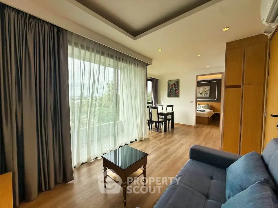 Spacious living room with large windows and modern decor in a stylish apartment.